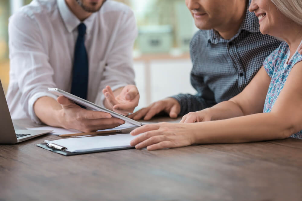 Male insurance agent consulting clients in office