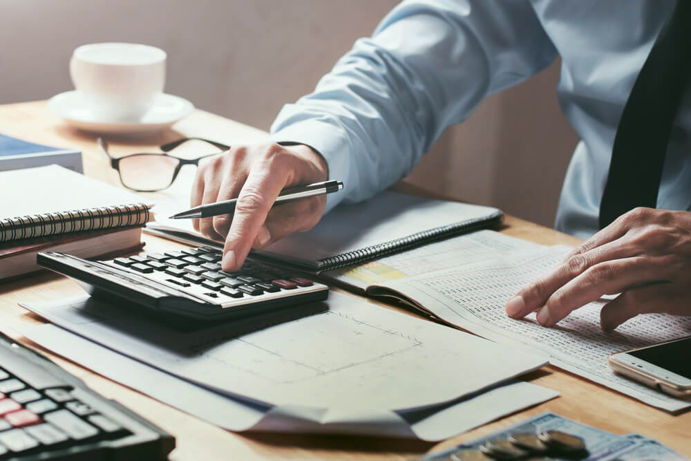 businessman working on desk office with using a calculator