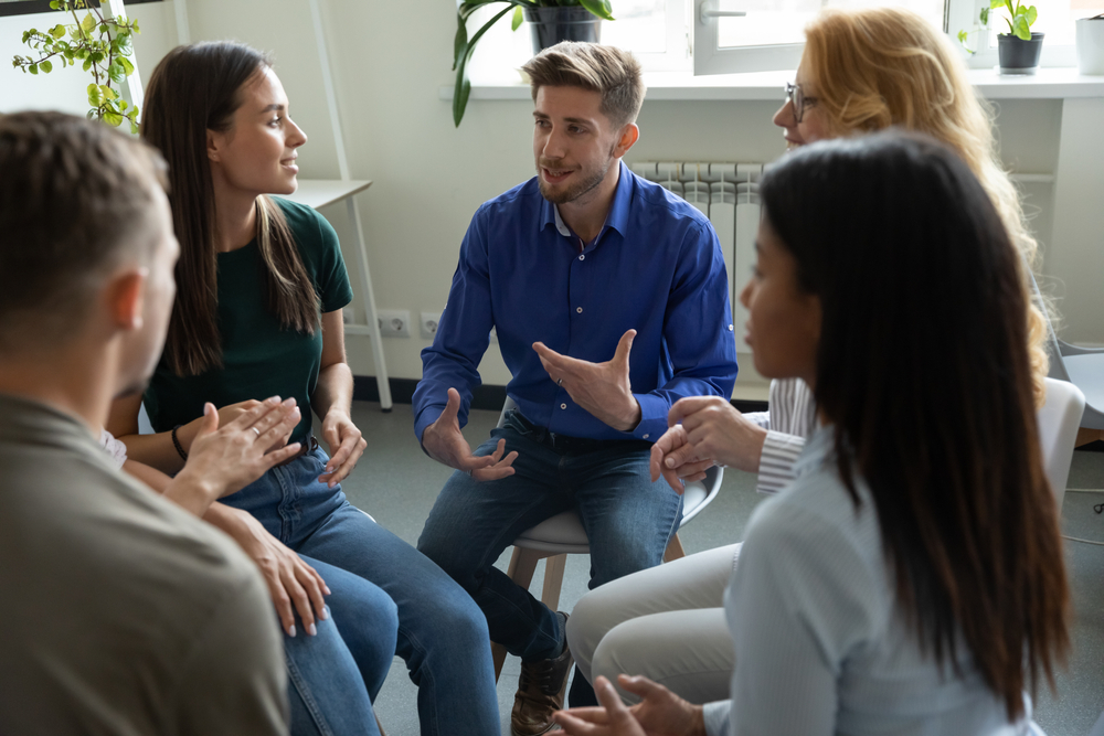 male mental health consultant talking in a group therapy