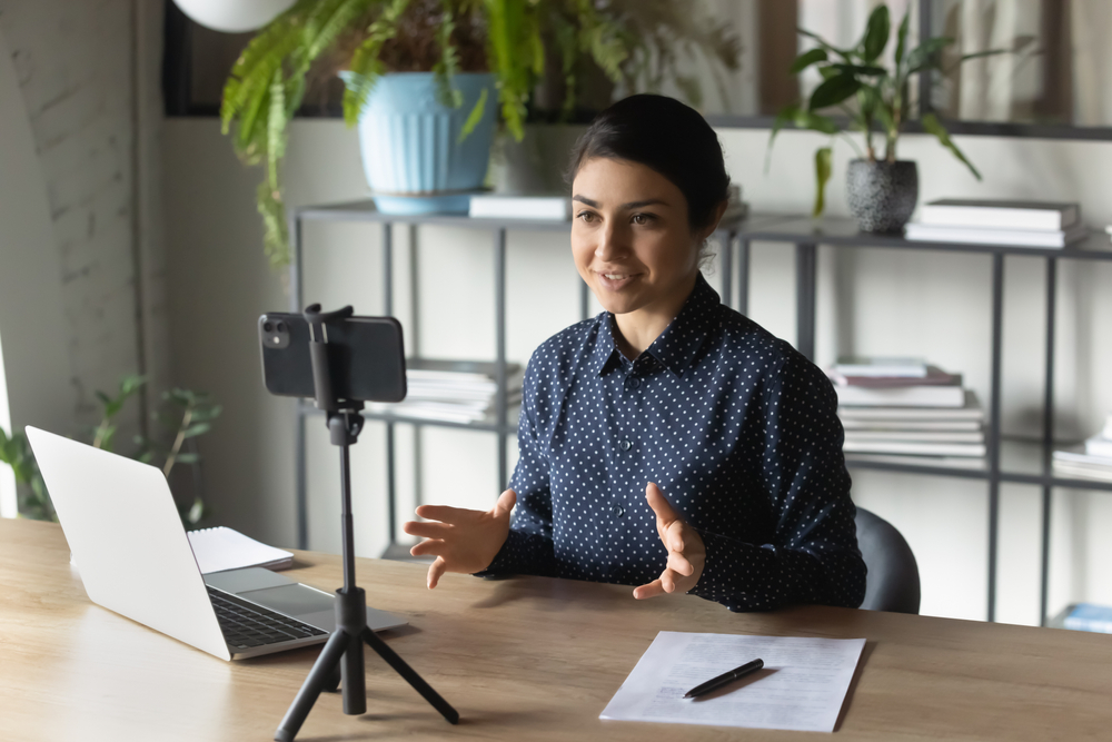 Confident woman recording a video resume at her work desk - Resumeble