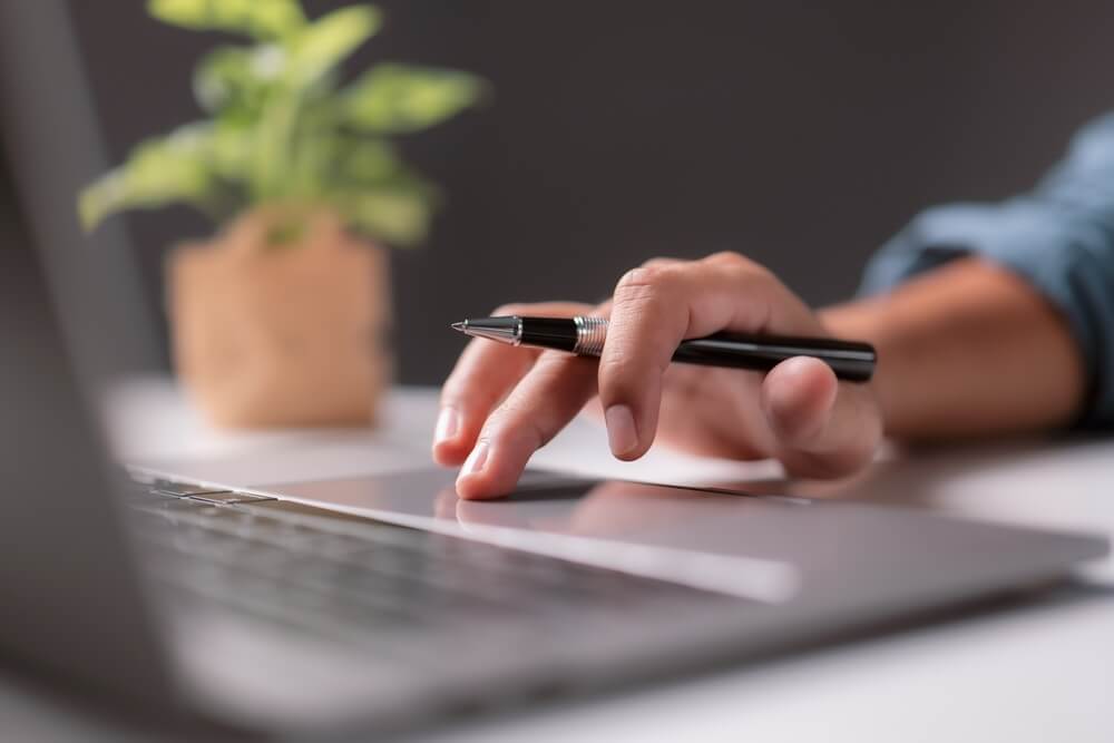 hand touching a laptop touchpad