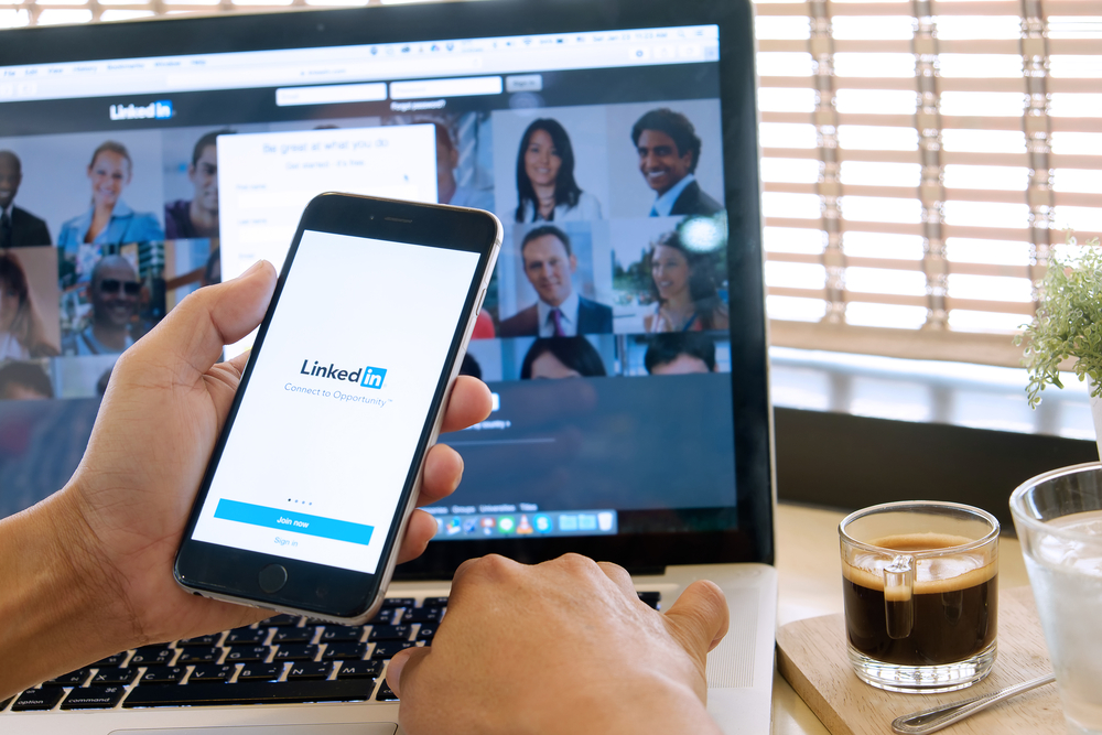 LinkedIn log in page showing on computer and cellphone screens