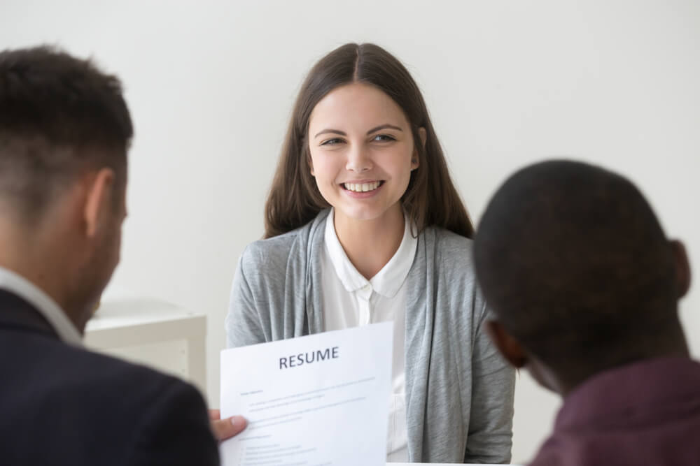 smiling female job applicant in front of two recruiters