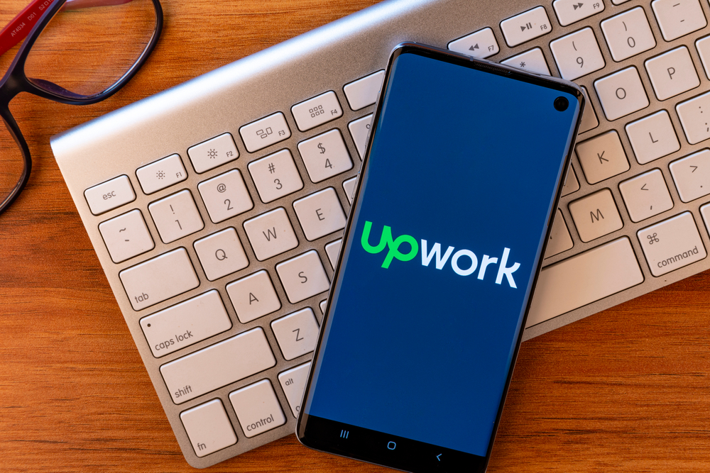 phone showing Upwork logo on keyboard